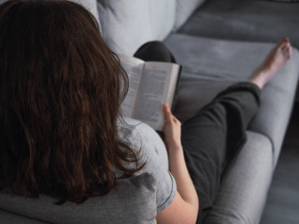 istock Relaxed woman on the sofa reading a book 1447131655