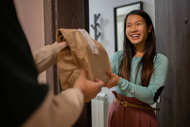 Courier delivering fast food to the customer Woman receiving delivery at home food delivery stock pictures, royalty-free photos & images