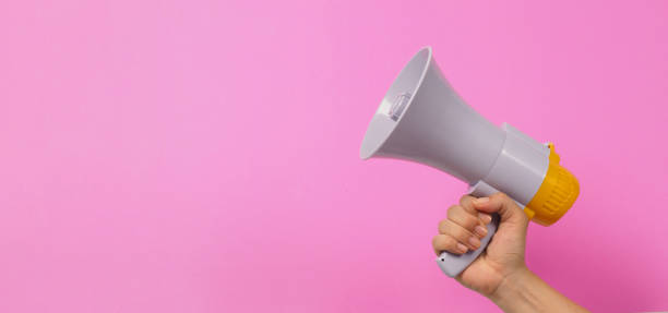 istock Hand is hold megaphone on pink background. 1447132539