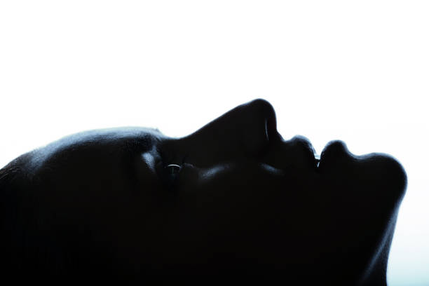 istock Part beautiful woman face silhouette covered in shadow 1447133986