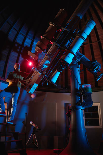 istock Astronomer with a big astronomical telescope in observatory doing science research of space and celestial objects. 1447134811