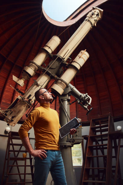 istock Astronomer with a big astronomical telescope in observatory doing science research. 1447134856