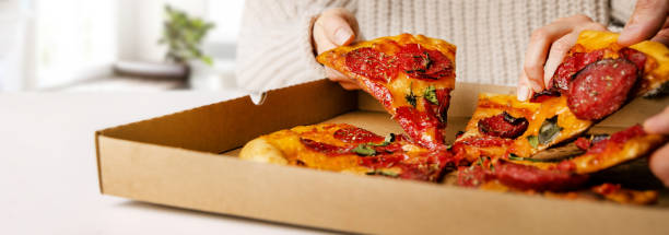 istock hands taking pizza slices from box. party snacks. banner with copy space 1447134892