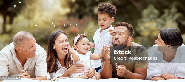 istock Happy, smile and big family blowing bubbles in a garden on a summer picnic in Puerto Rico. Happiness, grandparents and parents with children playing, having fun and relaxing together in the park 1447138859