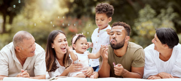 feliz, sorriso e grande família soprando bolhas em um jardim em um piquenique de verão em porto rico. felicidade, avós e pais com crianças brincando, se divertindo e relaxando juntos no parque - large family - fotografias e filmes do acervo