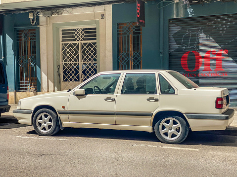 Side view of white Volvo car model 850 parked in the street. The Swedish manufacturer produced it from 1991 until 1996