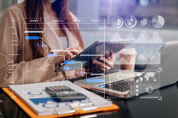 istock Businessman hand Project manager working and update tasks and Gantt chart scheduling virtual diagram.with smart phone, tablet and laptop in office. 1447139593