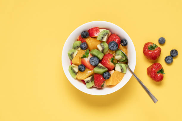 istock Bowl with fruit salad on yellow background 1447139786