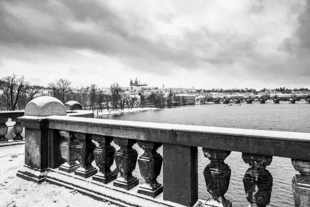 Winter Prague Panoramic Cityscape with Prague Castle, Charles Bridge and Vltava River. Czech Republic. Black and white image.