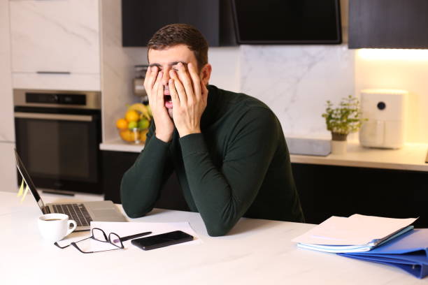 hombre con exceso de trabajo en la oficina en casa - frustration terrified worried glasses fotografías e imágenes de stock
