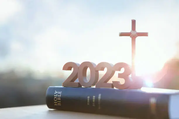 Photo of 2023 new year sunrise, the cross of Jesus Christ and the Bible