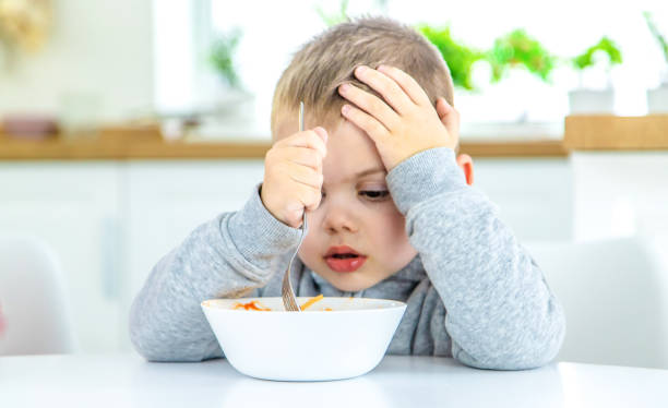istock children in the kitchen at the table turning pasta. 1447151816