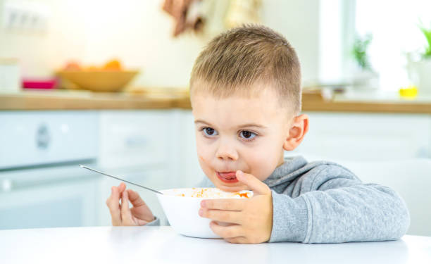 istock children in the kitchen at the table turning pasta. 1447151829