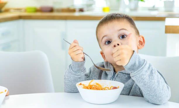 istock children in the kitchen at the table turning pasta. 1447151832