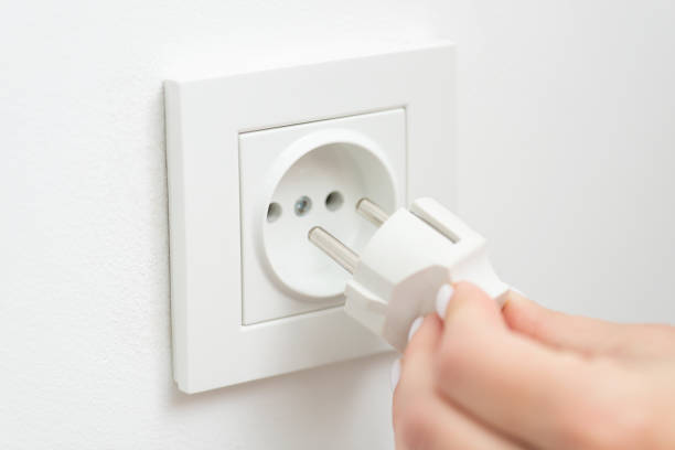 istock Inserting the electrical plug into outlet of the wall, white colour, close up 1447151867