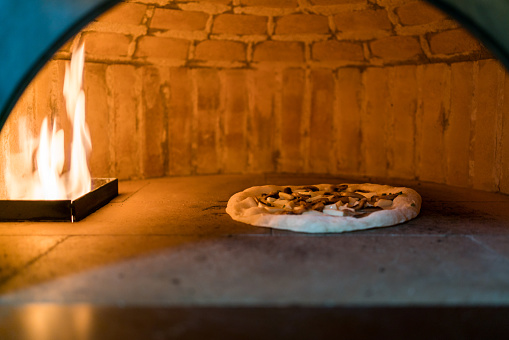 Inside the oven for Baking Neapolitan pizza in a gas-fired classic Italian pizza oven with high temperature. Crusts will quickly rise and toppings become lightly charred and crispy. Traditional baked