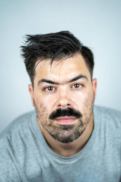 Confident American male entrepreneur with stubble. He is against white background.