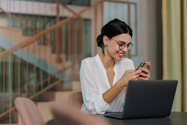 istock Elegantly dressed woman, working at the office, using a mobile phone. 1447151996