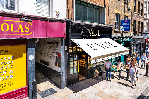 London, United Kingdom - June 22, 2018: High angle view on Paul French bakery, sandwich shop cafe sign with people on City of London Fleet street