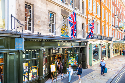 London, United Kingdom - June 22, 2018: Retail Hatchards bookstore, Fortnum & Mason department store with British flags, people on Piccadilly street