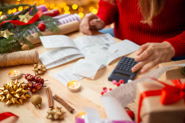 Close up of girl looking through checks of christmas expenses stock photo