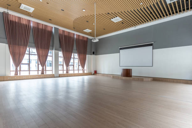 istock A spacious classroom with empty wooden ceiling and floor, with a platform and projection screen 1447158129