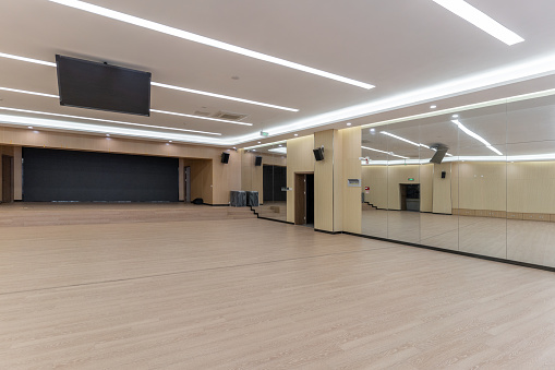 An empty unused wooden decorated hall with a large electronic screen
