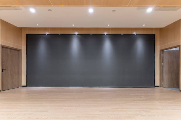 A large electronic screen on a wooden stage