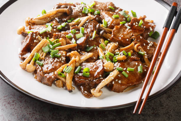 Stir-fried Beef Steak with Asian Mushroom close up on the plate. Horizontal Stir-fried Beef Steak with Asian Mushroom close up on the plate on the table. Horizontal buna shimeji stock pictures, royalty-free photos & images