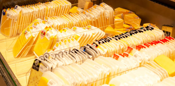 Showcase with rows of cheeses in a supermarket