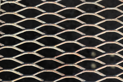 Background from a metal brilliant lattice on a black background.
