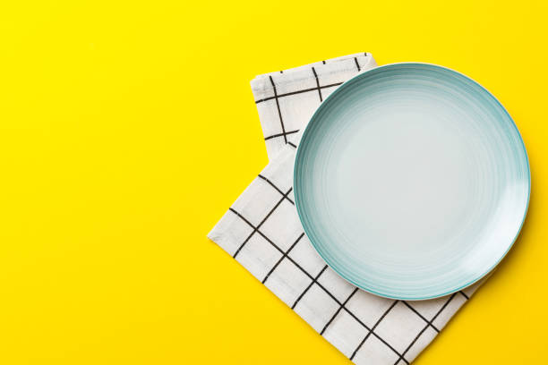 istock Top view on colored background empty round blue plate on tablecloth for food. Empty dish on napkin with space for your design 1447163452