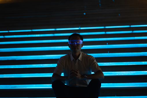 Man using smart glowing glasses under night light