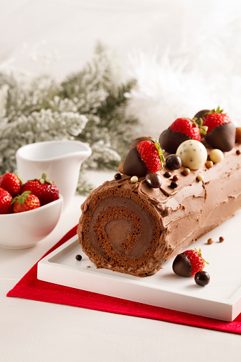 Chocolate log cake with strawberries for Christmas