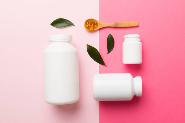 オメガ3カプセルは、緑色の葉の背景を持つテーブルの上の白いボトルにあります。魚油錠剤。生物学的に活性な添加剤。オメガ6、オメガ9、ビタミンa、e、d、ビタミンd3コピースペース付き� - nutritional supplement 写真 ストックフォトと画像