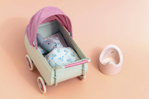 istock Miniature vintage baby stroller with a little bunny and potty. 1447168004