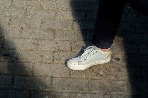 istock A woman's leg in a light sneaker on a dirty pavement 1447168091