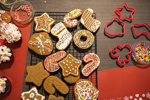 An assortment of Christmas cookies, plain and decorated, with cookie cutters and sprinkles