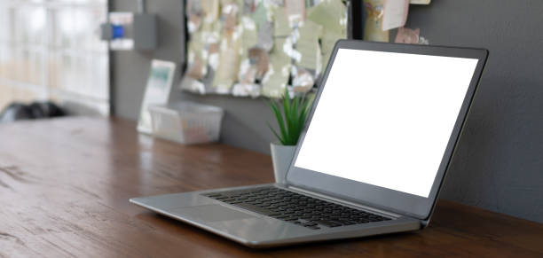 istock Laptop computer with white blank screen on wood desk. Workspace, workplace, desktop office concept. 1447172209