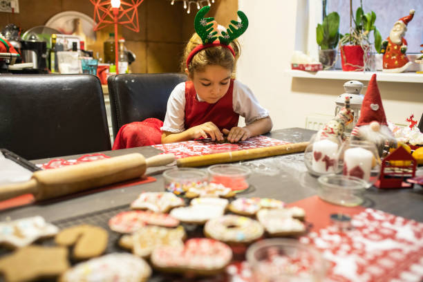 istock A cute girl carefully shaping gingerbread cookie dough 1447172253