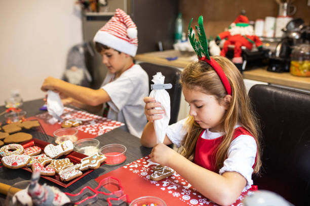 istock Cute kids decorating gingerbread cookies 1447172288