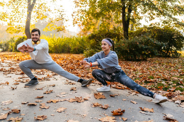 Young Couple Stretching Before Jogging In The Park