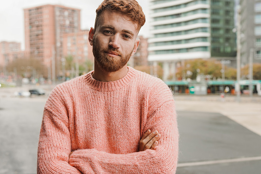 Young redhead man looking on camera