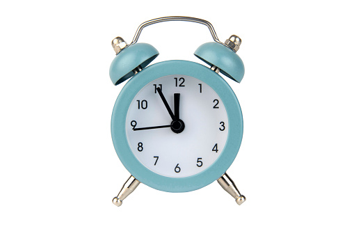 Vintage analog alarm clock isolated on a white background. Time 23-55. midnight