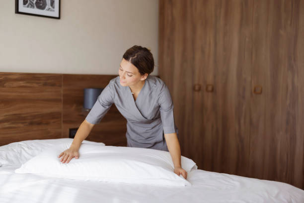 istock Maid Making Bed in Hotel Room 1447179332