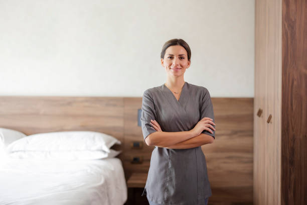 istock Smiling maid looking at camera in hotel room 1447179362