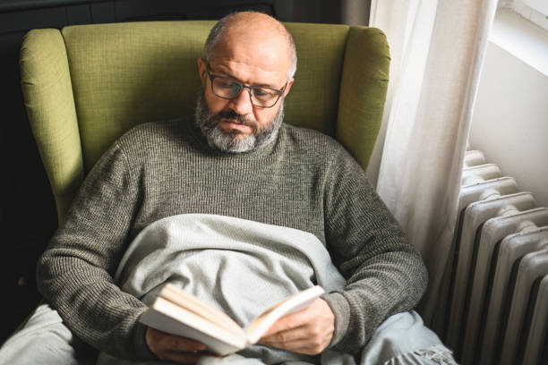 istock mature adult man in home interior ( book) 1447180142