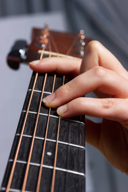 istock Woman's hand playing an acoustic guitar. 1447180552