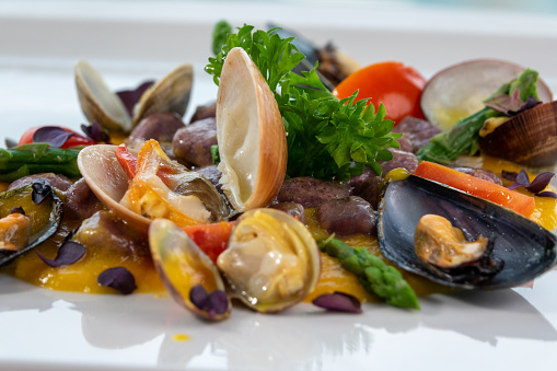 A bowl of delicious seafood and rice with shrimp, scallops, mussels, and calamari rings.