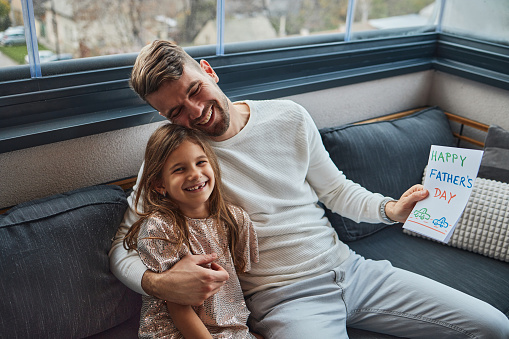 Beautiful girl is giving a card to her father. It is father’s day, so she drew a card to give to him. Happy father’s day!